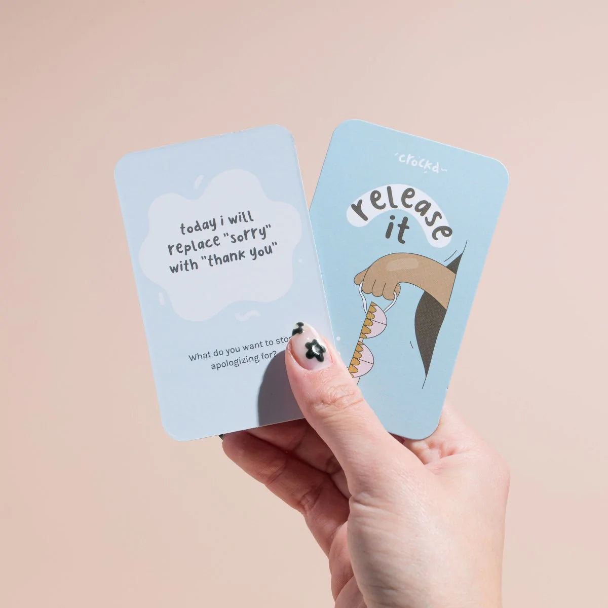 Hand holding up a โrelease itโ card by crockd