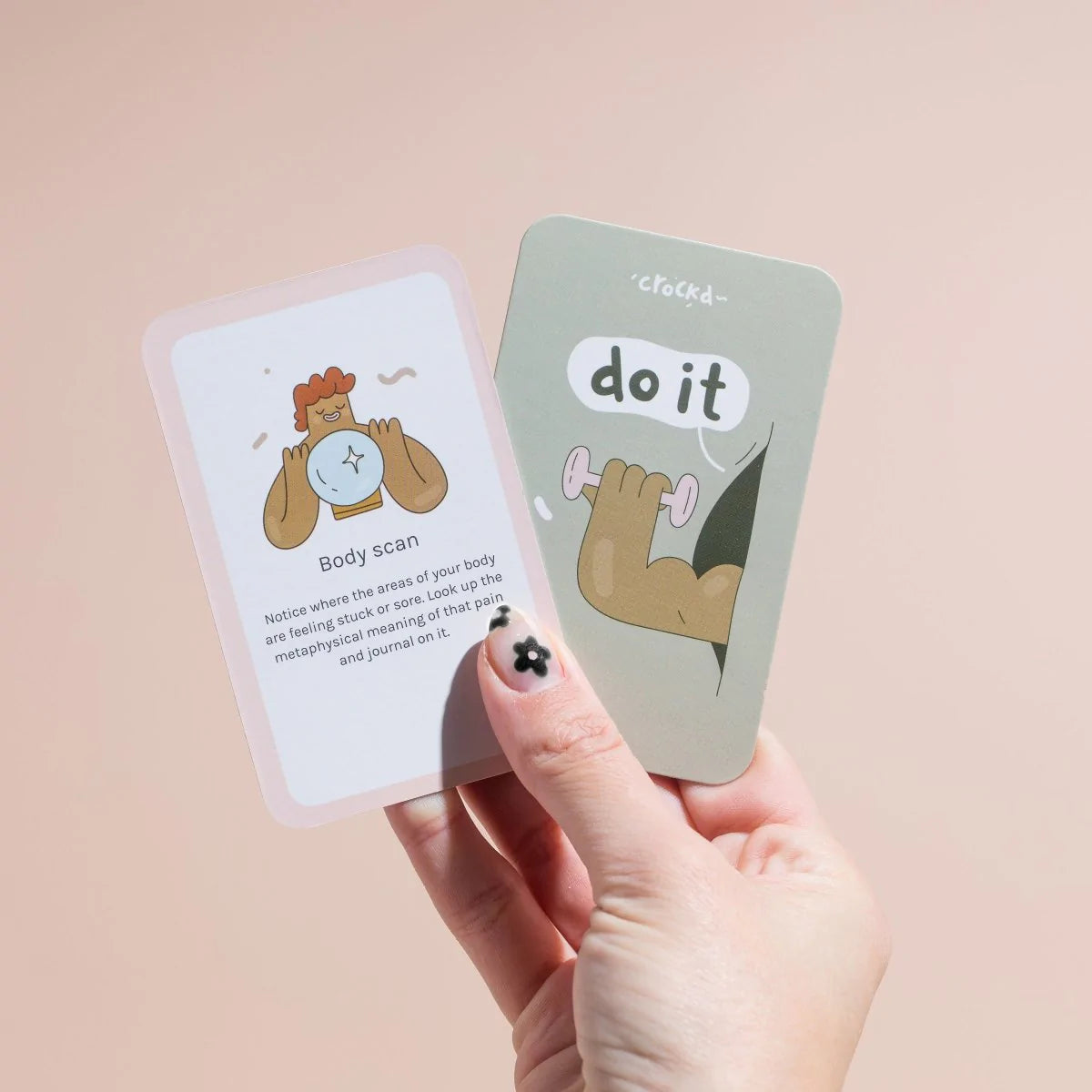 Hand holding up a โdo itโ card by crockd